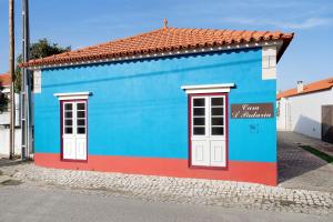 een blauw en rood gebouw met twee ramen bij Casa da Padaria in Leiria