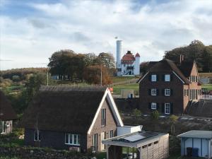 un grupo de casas con una torre de agua en el fondo en Breidablik, en Lohme