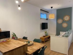 a living room with a table and a dining room at Nid douillet tout équipé in Château-Renault