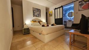 ein Schlafzimmer mit einem Bett, einem TV und einem TV in der Unterkunft Gunlayer Maisonette in Floriana