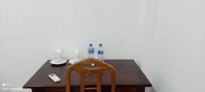 a wooden table with a chair and bottles on it at Jungle Edge Home Sigiriya in Sigiriya