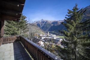 a balcony with a view of a town and mountains at Chasa Avant Porta in Ramosch