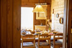 a kitchen with a wooden table with chairs and a dining room at Chasa Avant Porta in Ramosch