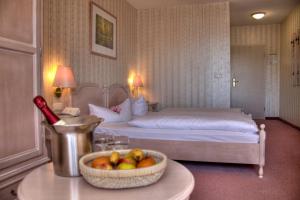 a hotel room with a bed and a bowl of fruit on a table at Hotel am Markt Altentreptow in Altentreptow