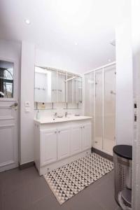 a white bathroom with a sink and a shower at Grand Appartement a Maison sculptée in Autun