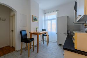 a kitchen with a table and chairs and a refrigerator at Wifi Netflix free parking Gruben Apartment in Schaffhausen