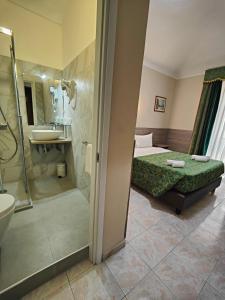 a bathroom with a bed and a shower and a sink at Hotel Romano in Turin
