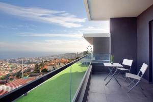 a room with a balcony with a table and chairs at Dream View in Funchal