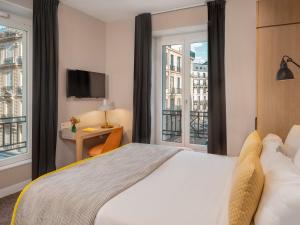 a hotel room with a bed and a balcony at Hotel Le Mareuil in Paris