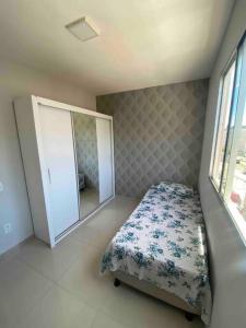 um quarto com uma cama, uma cómoda e um espelho em Lindo 2/4 em Abrantes. em Lauro de Freitas