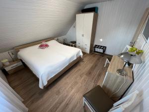 a bedroom with a white bed and a lamp at Harzliebhaber 2 in Altenau