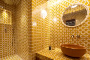 ein gelb gefliestes Bad mit einem Waschbecken und einem Spiegel in der Unterkunft Casa Lilia - Florence in Florenz