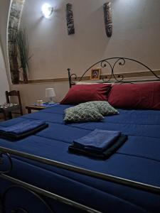 un letto con lenzuola blu e due asciugamani sopra di La piazzetta a Linguaglossa