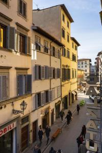 eine Gruppe von Menschen, die eine Straße mit Gebäuden entlang gehen in der Unterkunft Casa Lilia - Florence in Florenz