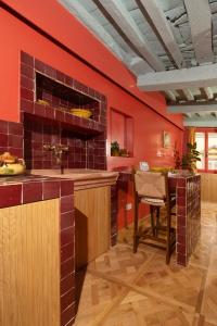 eine Küche mit roten Wänden und einem Holztisch in der Unterkunft Casa Lilia - Florence in Florenz