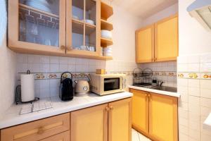 uma cozinha com armários amarelos e um micro-ondas em Résidence Marie-Thérèse em Le Grau-du-Roi