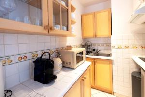 a kitchen with a counter top with a microwave at Résidence Marie-Thérèse in Le Grau-du-Roi