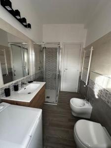 a bathroom with two sinks and a toilet and a shower at Sweet house Malpensa in Somma Lombardo