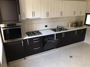 a kitchen with black cabinets and a sink at VILA DE PE DEAL in Poiana Stampei