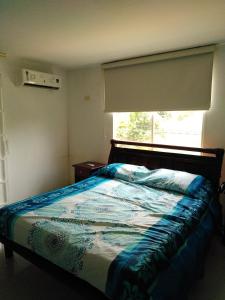een slaapkamer met een bed en een raam met een schaduw bij casa hostal rochymar in Juan de Acosta