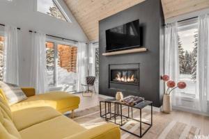 a living room with a yellow couch and a fireplace at Dahlia 2 avec piscine in Valcartier Station