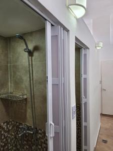 baño con ducha y puerta de cristal en Salta eco alojamiento en Salta