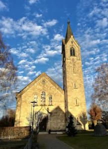 a church with a tower with a clock on it at Romantische Zeitreise in historischer Käserei in Unlingen