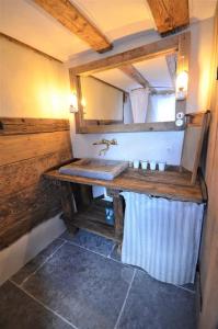 a bathroom with a wooden sink and a mirror at Romantische Zeitreise in historischer Käserei in Unlingen