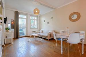 uma sala de estar com uma mesa e um sofá em Charming 2 bedroom apartment with terrace em Lille