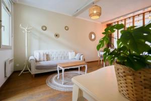 a living room with a white couch and a table at Charming 2 bedroom apartment with terrace in Lille