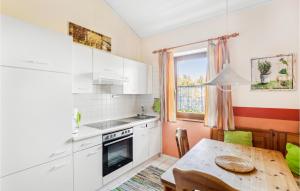 a kitchen with white cabinets and a table and a window at Beautiful Home In Falkenstein With Kitchen in Falkenstein