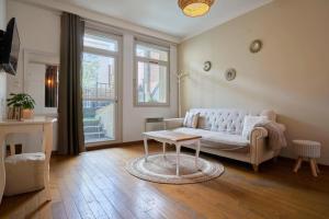 un soggiorno con divano e tavolo di Charming 2 bedroom apartment with terrace a Lille