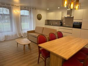 a living room with a table and a kitchen at Résidence de la Roseraie in Florenville