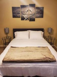 a bedroom with a bed with four pictures on the wall at I Deal Lake Powell Home 3BR, Jacuzzi, BBQ, Firepit in Page