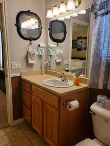 a bathroom with a sink and a toilet and two mirrors at I Deal Lake Powell Home 3BR, Jacuzzi, BBQ, Firepit in Page
