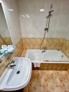 y baño con lavabo blanco y bañera. en Bicis & Vacas, en La Pola de Gordón