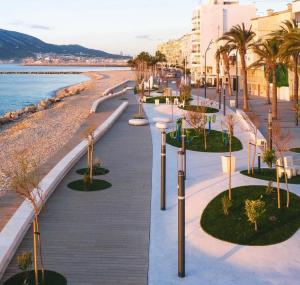 a street with palm trees and a beach at El rincon de Mauro in Altea
