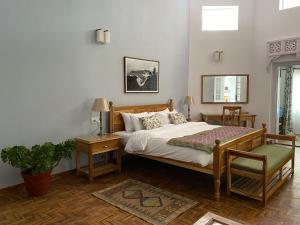een slaapkamer met een bed, een tafel en een stoel bij SaffronStays Dunnottar North By Kodai Lake- A 2-BDR villa in Kodaikānāl