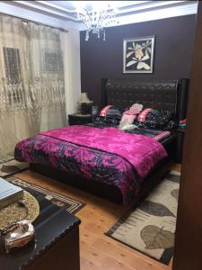 sypialnia z łóżkiem z fioletową kołdrą w obiekcie شقه فندقيه الترا سوبر لوكس بارقي مناطق اسيوط w mieście Asjut