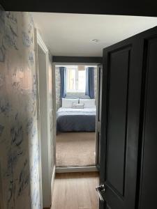 a bedroom with a bed and a door leading into a room at Most Easterly Guest House in Pakefield