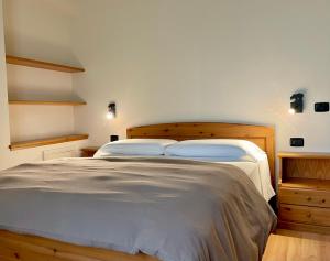 una camera da letto con un grande letto con lenzuola bianche di Casa Mezzavalle a Pelugo