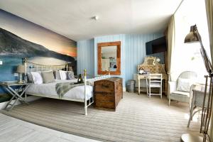 a bedroom with a bed and a painting on the wall at Lulworth Cove Inn in Lulworth Cove