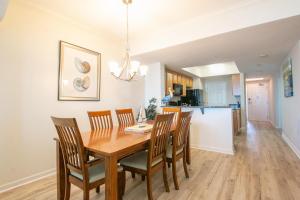 comedor y cocina con mesa de madera y sillas en Legacy I 1206, en Gulfport