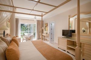 a living room with a bed and a television at Bahia Principe Grand El Portillo - All Inclusive in Las Terrenas