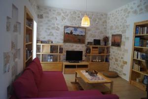 een woonkamer met een bank en een tv bij Μyrsini in Ierápetra