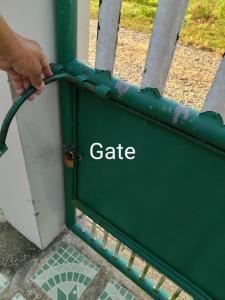 a person holding a green gate with the word gate at Leigh HomeStay in Alaminos