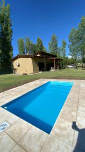 una piscina azul frente a una casa en Casa Encanto Uco, en Tunuyán