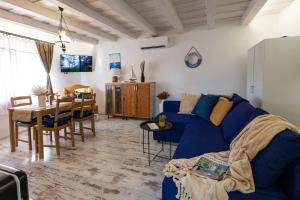 a living room with a blue couch and a table at Malomvölgyi Vendégház in Balatonalmádi