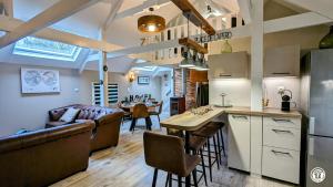 een keuken en een woonkamer met een bank en een tafel bij Le Chalet de la Combe Sainte-Anne in Selongey
