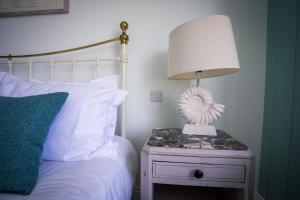 a lamp on a night stand next to a bed at Lulworth Cove Inn in Lulworth Cove